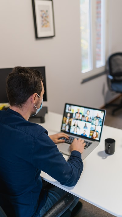 The man in blue long sleeve shirt with black notebook computers
